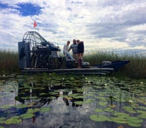 People on airboat in lily pad marsh.