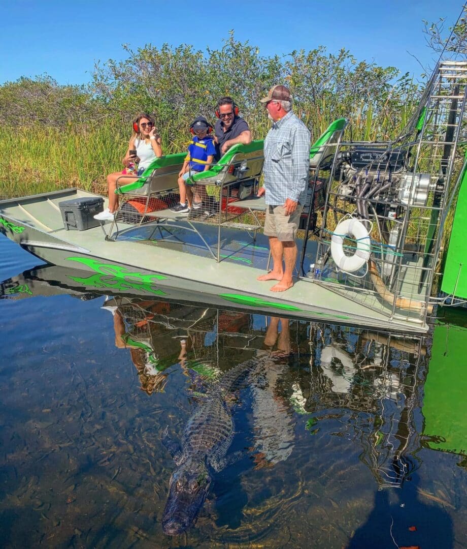 Airboat tour with family and alligator nearby.